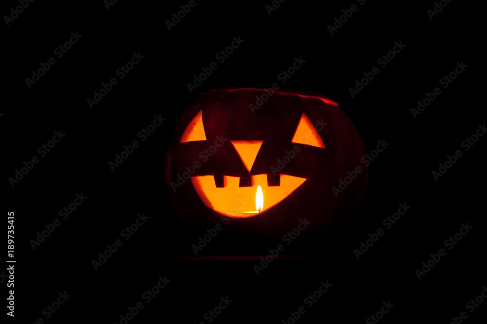Halloween pumpkin with burning candle on black background Halloween pumpkin with burning candle on black background