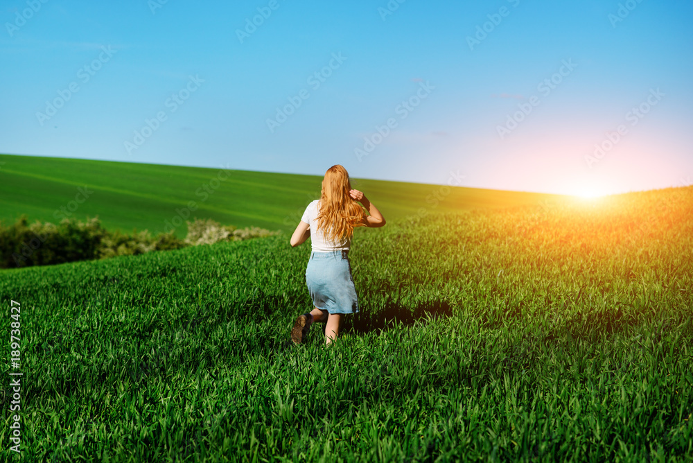 Young beautiful woman running on a green field Young beautiful woman running on a green field