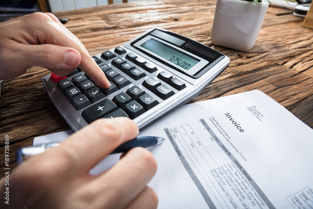 Person's Hand Calculating Invoice Person's Hand Calculating Invoice
