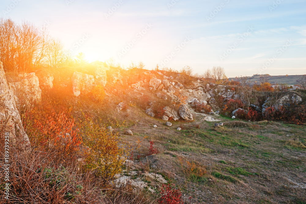 Fototapeta premium View on the beautiful colorful autumn landscape of the hills with trees, rocks and greenfields in the countryside