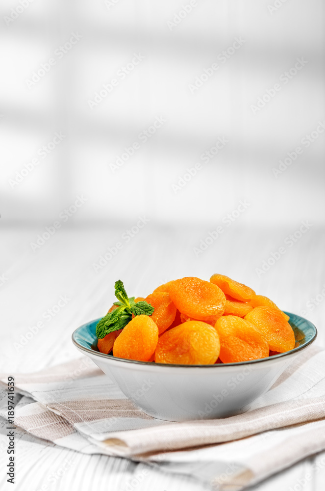 Delicious dried apricots in a plate on the table. Copy Space. The concept is healthy food, diet, vegetarianism. Delicious dried apricots in a plate on the table. Copy Space. The concept is healthy food, diet, vegetarianism.