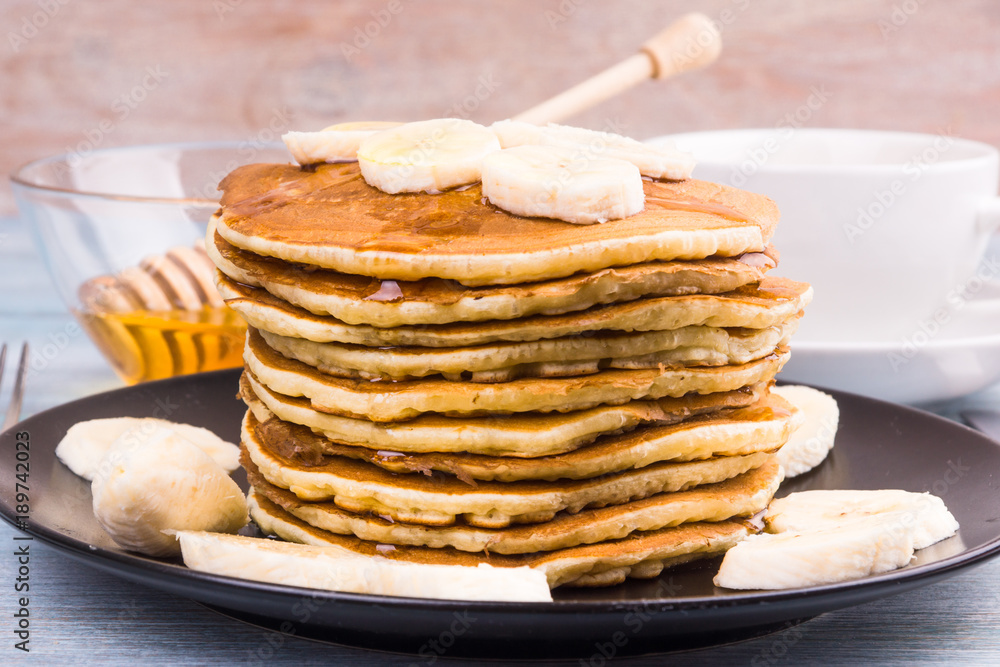 Delicious traditional American pancakes with banana slices and honey Delicious traditional American pancakes with banana slices and honey