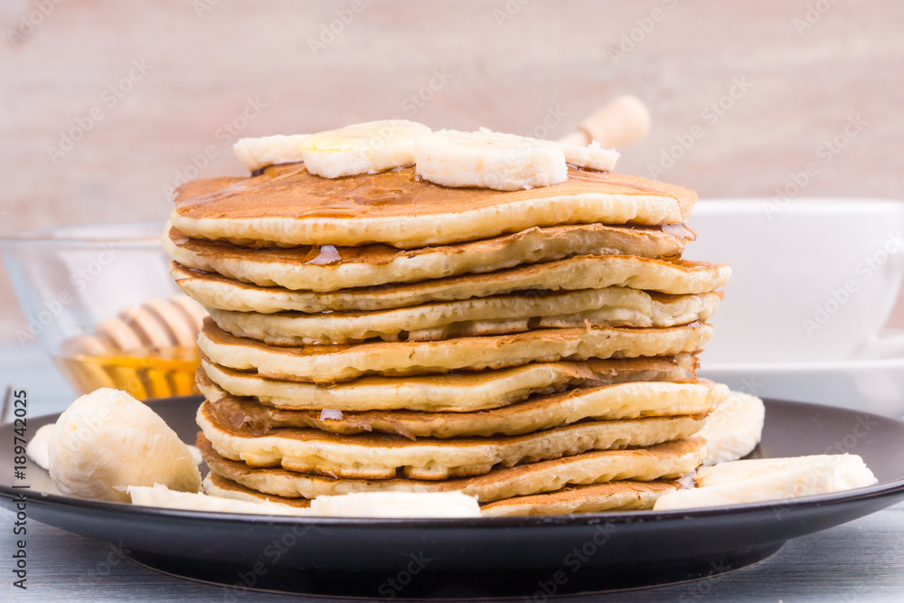 Delicious traditional American pancakes with banana slices and honey Delicious traditional American pancakes with banana slices and honey