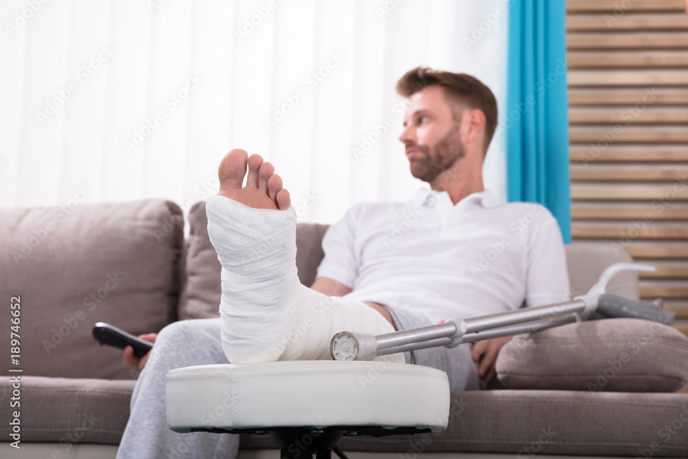 Man With Broken Leg Sitting On Sofa Man With Broken Leg Sitting On Sofa