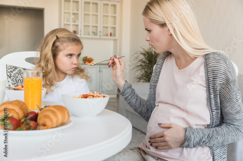 daughter rejecting pregnant mothers meal in kitchen