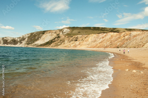 Beautiful summertime beach and ocean waves along Tyneham beach in Dorset, England.
