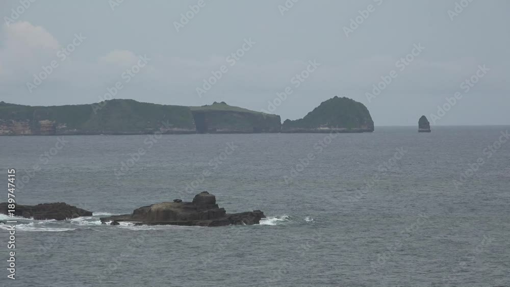 A lonely standing rock in the waves of the Indian Ocean nearby the coast of Lombok A lonely standing rock in the waves of the Indian Ocean nearby the coast of Lombok