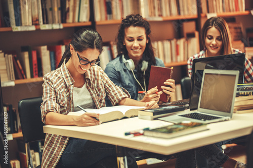 Female students study in the college library.Learning and preparing for exam. photo