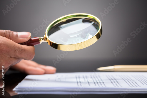 Judge Looking At Document With Magnifying Glass