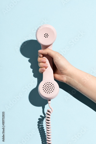 Woman's hand holding a pastel telephone