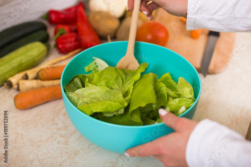 Close up photo of making salad in kitchen.