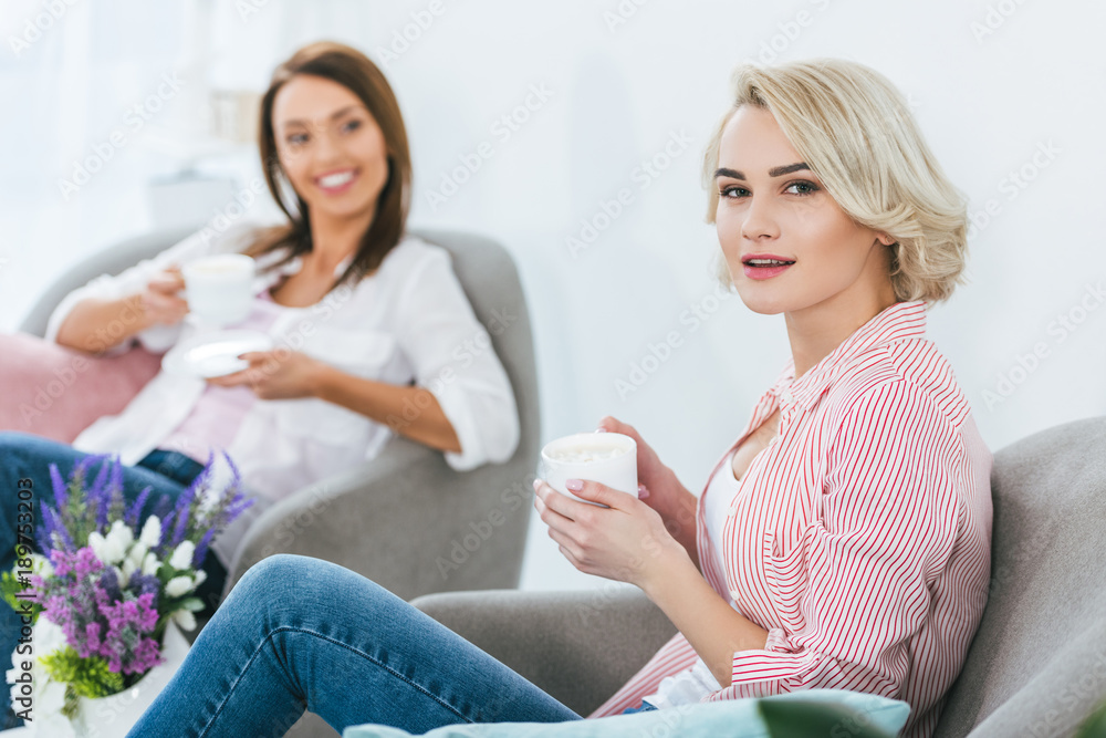 selective focus of women with coffee cups spending time together selective focus of women with coffee cups spending time together