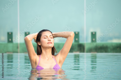 Asian woman resting at pool. Woman with relax emotion.