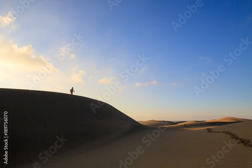 Two tourists walking at sand desert in Maspalomas on Gran Canaria.