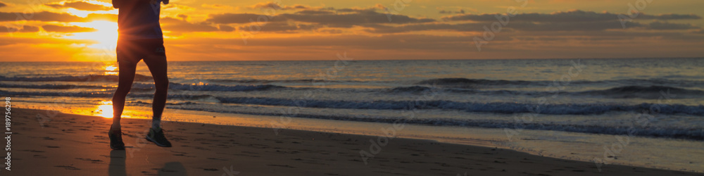 Runner legs on the beach during the sunrise.