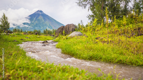 River near Mayon Volcano is an active stratovolcano in the province of Albay in Bicol Region, on the island of Luzon in the Philippines. Renowned as the perfect cone because of its symmetric conical photo