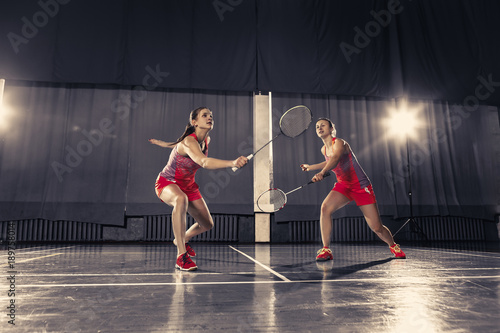 Canvas Print Young women playing badminton at gym