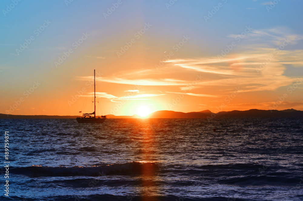 Bright saturated sunset on the sea and a rocking boat on the waves Bright saturated sunset on the sea and a rocking boat on the waves