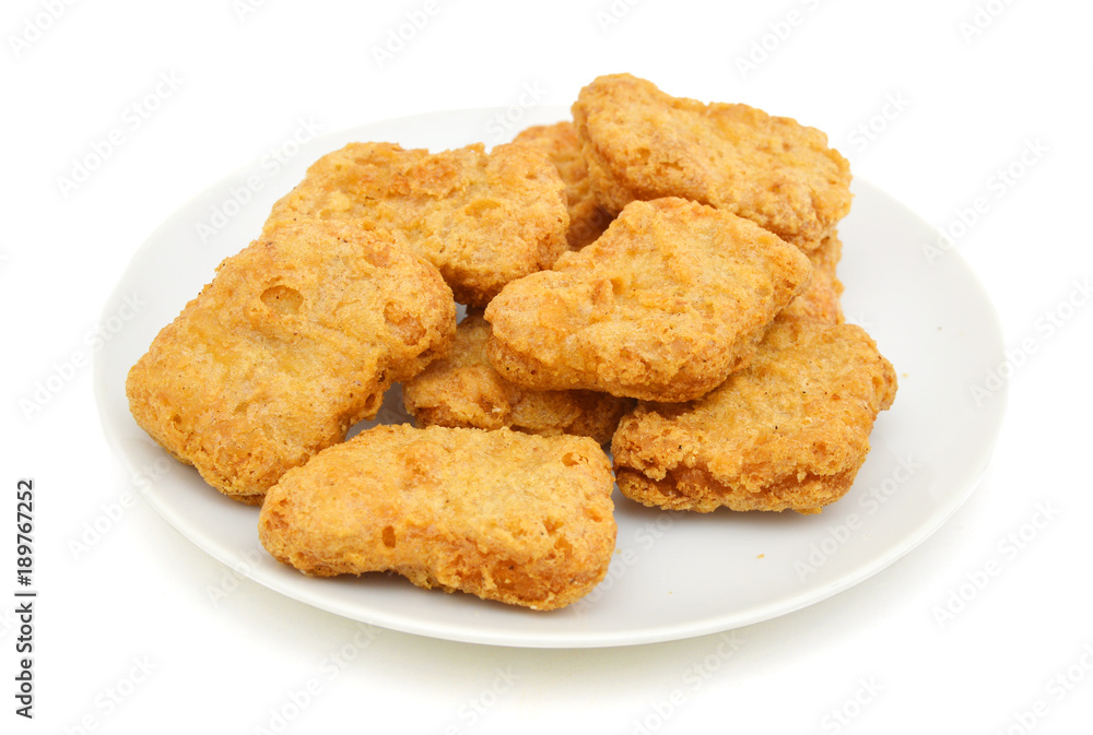 Macro of fried chicken nuggets in white plate on white background