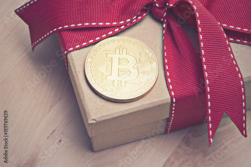 Bitcoin on gift box with red ribbon