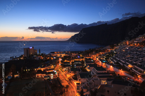 residential apartments in the background of Los Gigantes Cliffs  Tenerife  Spain