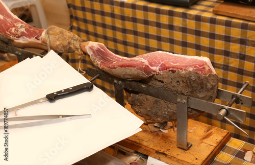 expensive raw ham in the deli for cutting by the butcher photo