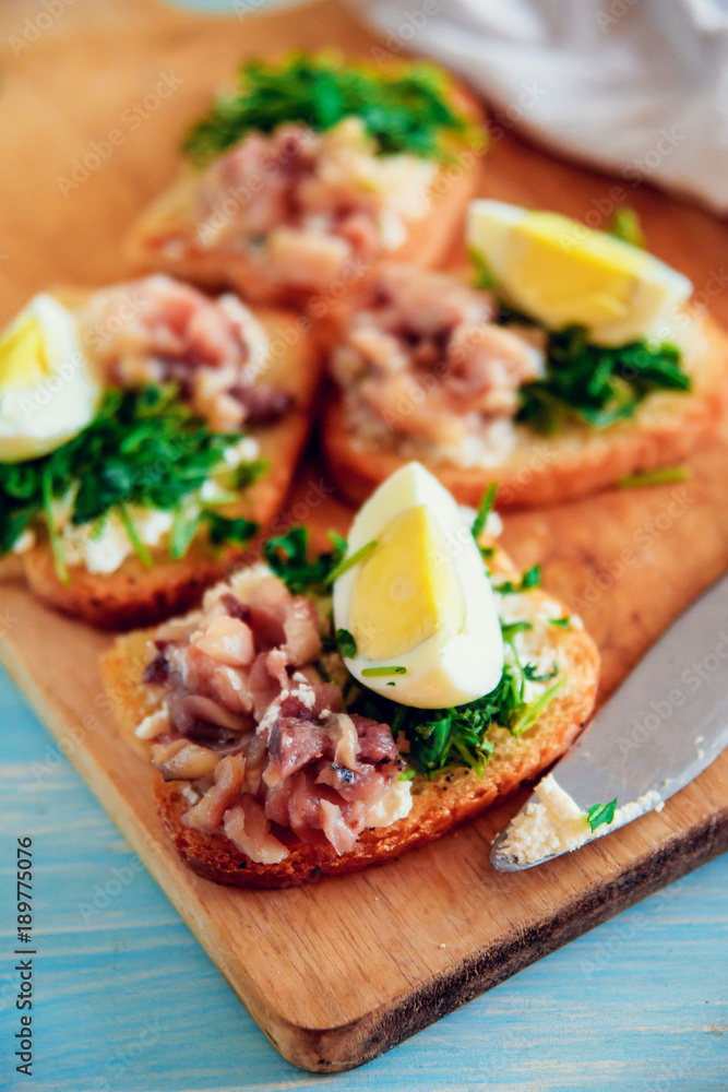 bruschetta, appetizer, canapes: fish and spinach on toast of white bread, with egg