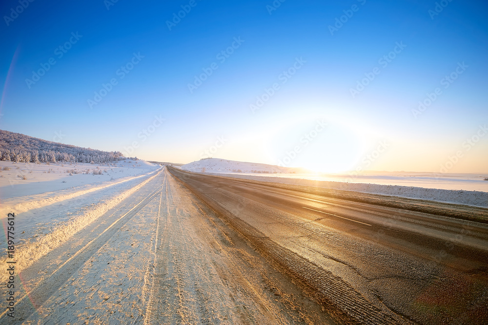 Winter road through snowy fields and forests Winter road through snowy fields and forests