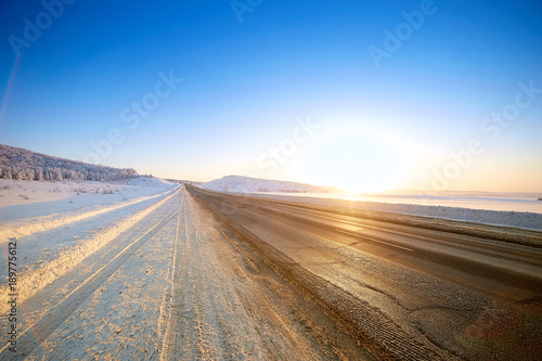 Winter road through snowy fields and forests