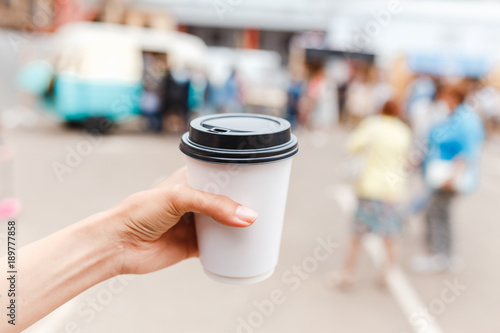 hand of young woman holding disposable cup photo