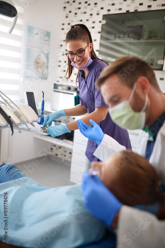 Dental assistant and dentist working with patient