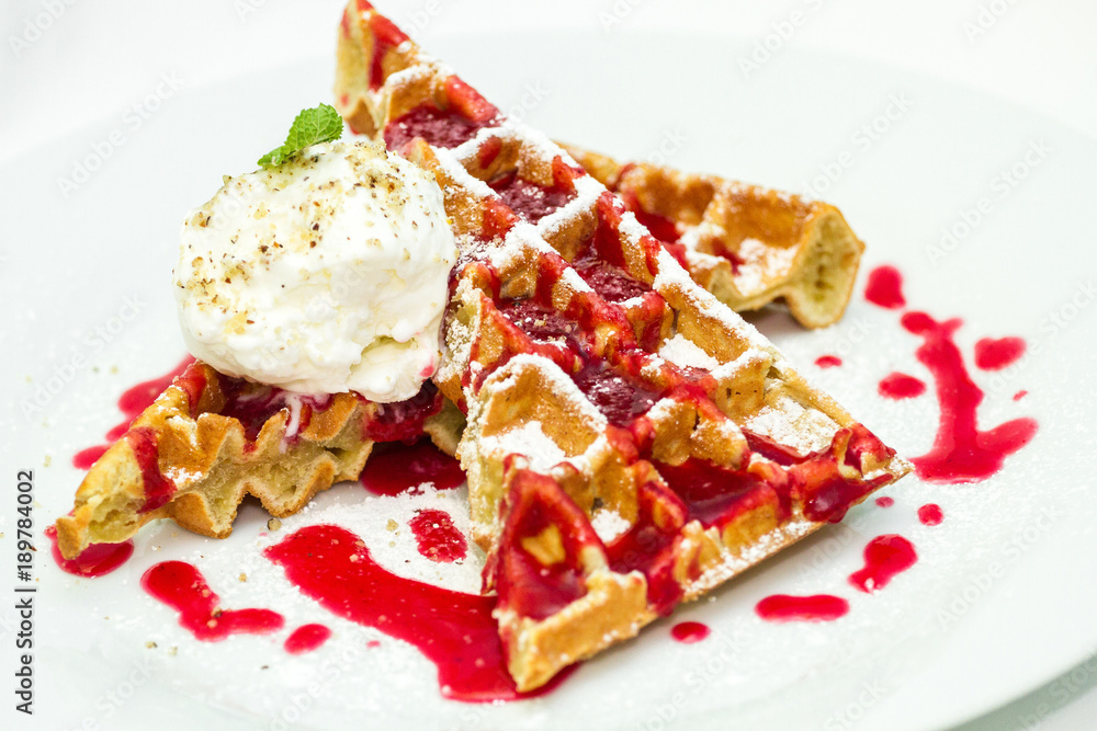 Belgium waffles with fruit sauce, ice cream with nut crumb and mint isolated on white background Belgium waffles with fruit sauce, ice cream with nut crumb and mint isolated on white background