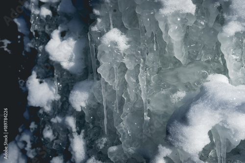 Very fragile ice formations and icicles underneath the wall of a sandstone cave and frozen icicles dangling from the ceiling at Matthiessen State Park in Utica, Illinois. photo