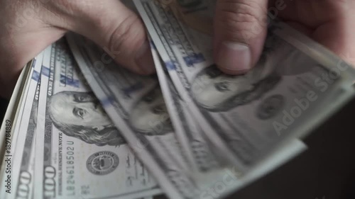 Business finance market. Man holding American dollars in hands, recounts money, currency, dollar. One hundred dollar bills. Only hands with money close up. Bribe