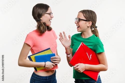 Friendship of two teenage girls. On a white background  the girls talk and laugh