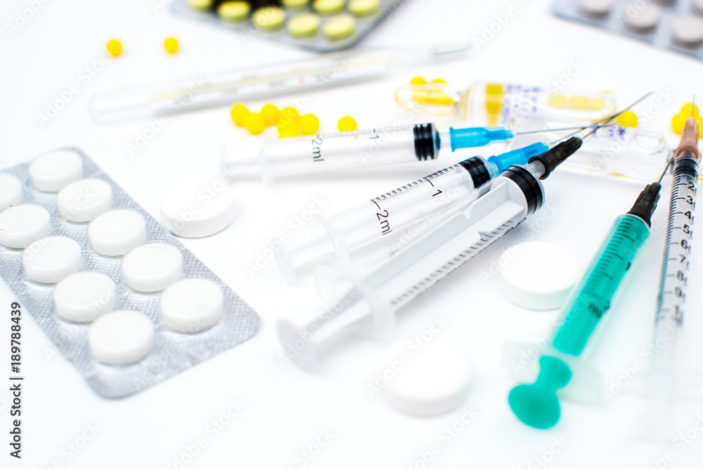 Syringes and pills different as the background on a white background Syringes and pills different as the background on a white background