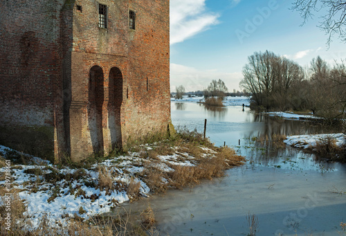 Ruin of old castle at the IJssel river in winter. photo