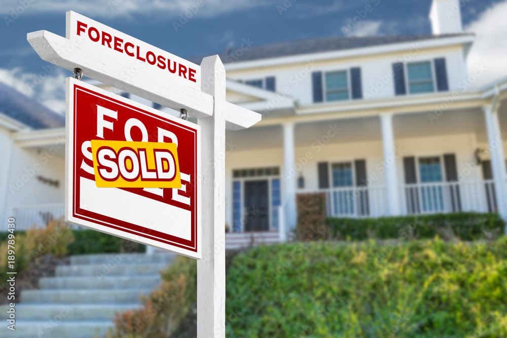 Left Facing Foreclosure Sold For Sale Real Estate Sign in Front of House. Left Facing Foreclosure Sold For Sale Real Estate Sign in Front of House.