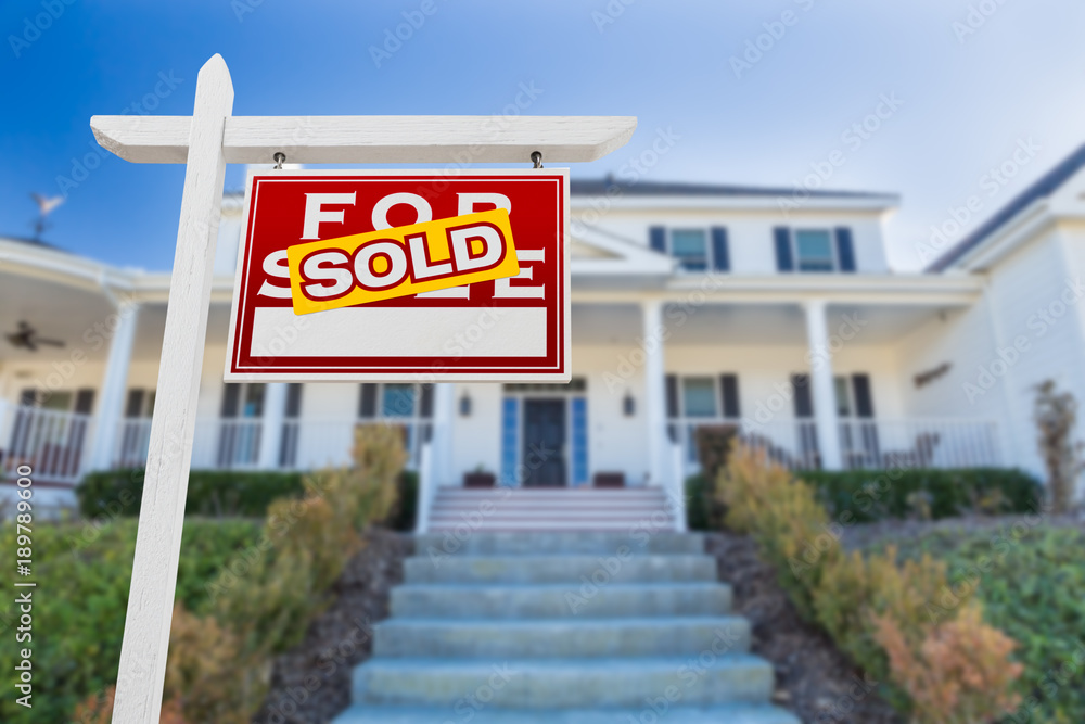 Right Facing Sold For Sale Real Estate Sign In Front of House. Right Facing Sold For Sale Real Estate Sign In Front of House.
