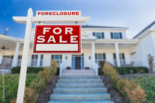 Right Facing Foreclosure For Sale Real Estate Sign in Front of House.
