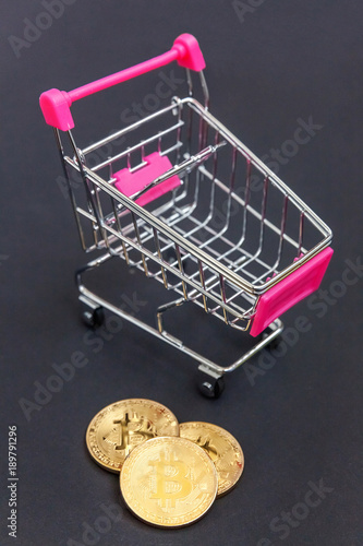 Stack of coins bitcoin in mini shopping cart toy, concept of mining. Electronic virtual money for web banking and international network payment. Symbol of crypto currency photo