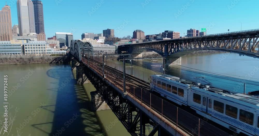 A slow forward aerial view of subway cars traveling on a railroad bridge over the Monongahela River in downtown Pittsburgh, PA. A slow forward aerial view of subway cars traveling on a railroad bridge over the Monongahela River in downtown Pittsburgh, PA.