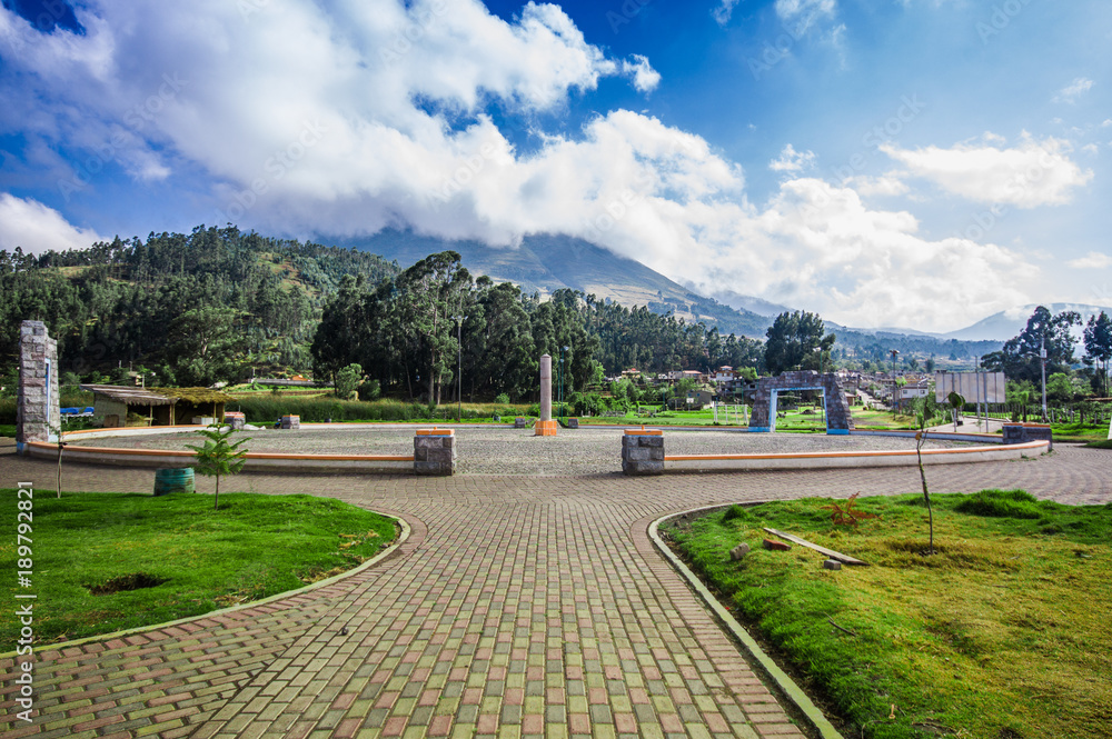 Fototapeta premium Beautiful outdoor view of stoned parking place in a beautiful day with blue sky and some clouds, with a forest behind