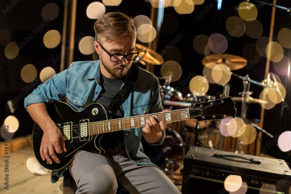 Fototapeta premium man playing guitar at studio rehearsal