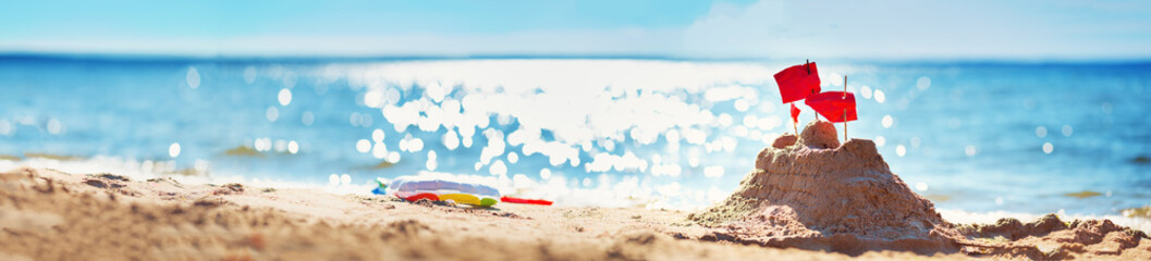 Sandcastle on the sea in summertime. Seashore on beautiful day