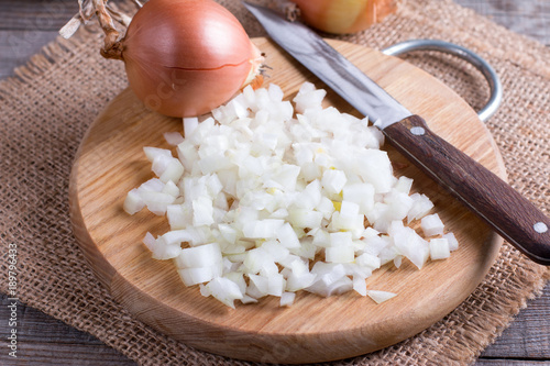 Fotografía Raw onion, chopped cubes on a wooden board