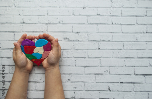 Slika na platnu Child's hands holding a heart on white background with text space