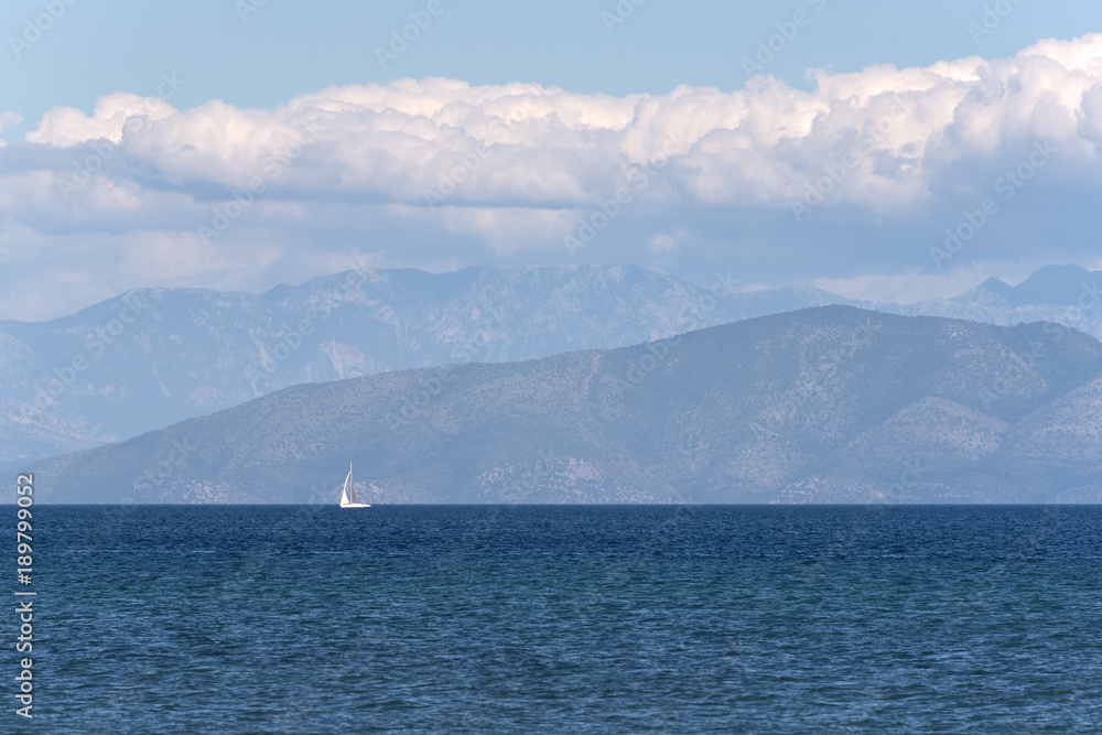 Alone sailing boat on blue sea.
