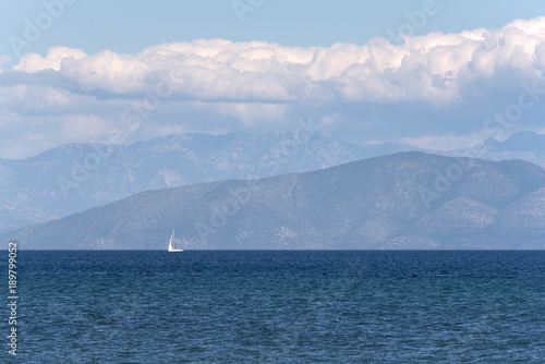 Alone sailing boat on blue sea.