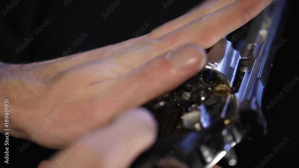 Man put bullet into revolver, spinning barrel, going to play Russian roulette Man put bullet into revolver, spinning barrel, going to play Russian roulette